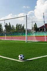 soccer ball on green grass in front of goal net