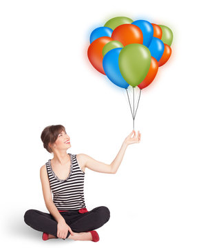 Young woman holding colorful balloons