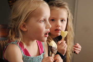 Zwei kleine Mädchen essen Eis am Stiel