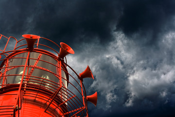 Red lightship with fog horns against storm clouds