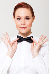 elegant young waitress holding on to bow tie