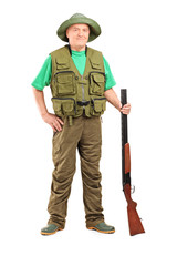 Full length portrait of a male hunter holding a shotgun