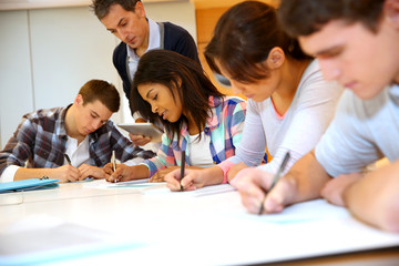 Fototapeta na wymiar Group of teenagers in class writing an exam