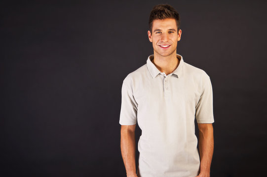 Man In Grey Polo T-shirt On Black Backgraund With Smile