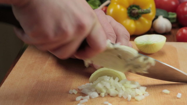 Chef cutting up an onion with a knife, tracking shot