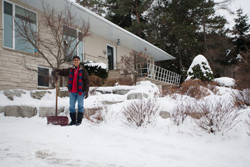 East Indian man shovelling snow