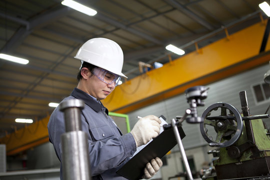 mechanical technician writing on notepad
