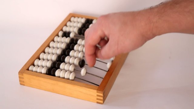 Male hand using the abacus to calculate basic algebra