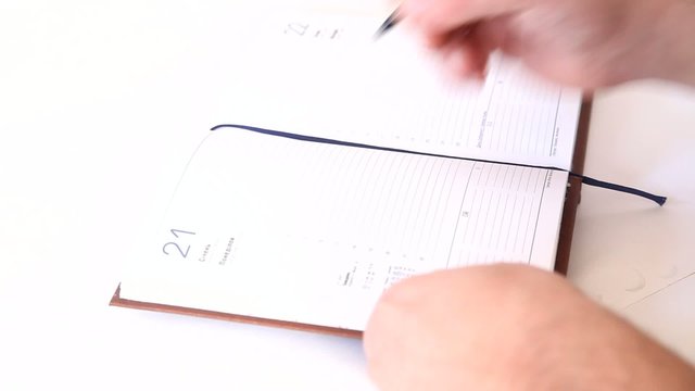 Man writing information in agenda book