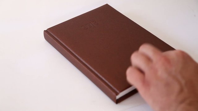 Man writing information in agenda book