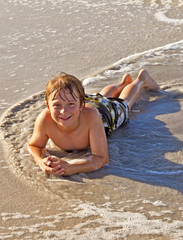 boy lying at the beach and enjoying the sun