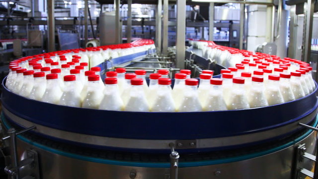bottles with milk at factory moves in circle