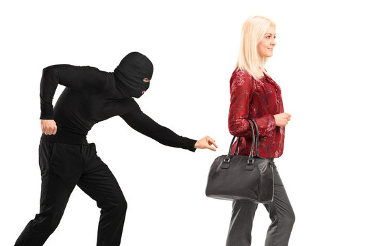 A pickpocket with mask trying to steal a from a woman carrying a