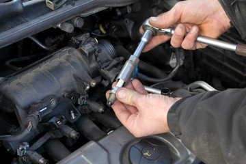 Fototapeta premium Car gasoline engine servicing, ratchet and spark plug