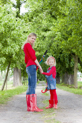 Fototapeta premium mother and her daughter with umbrellas in spring alley