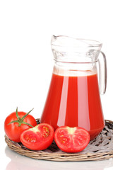 Tomato juice in pitcher on wicker mat isolated on white