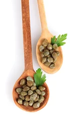 Foto op Canvas green capers in wooden spoons on white background close-up © Africa Studio
