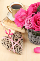 Beautiful pink roses in vase on wooden table close-up