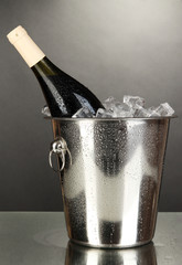 Bottle of wine in ice bucket on black background