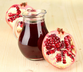 Full jug of pomegranate juice,on wooden background