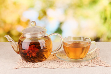 Exotic green tea with flowers in glass teapot