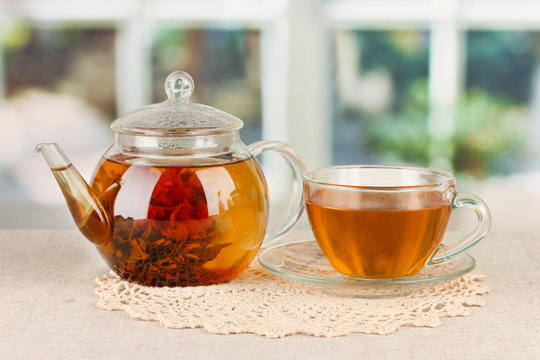 Exotic green tea with flowers in glass teapot