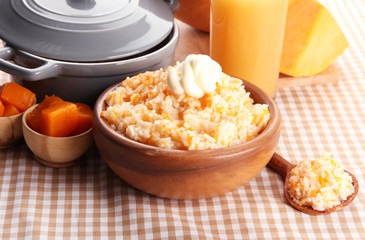 Taste rice porridge with pumpkin and glass of juice