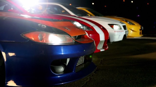Four cars with colorful sport design at night