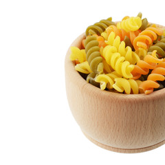 Wooden bowl of trricolor fusilli pasta isolated over white backg