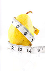 Yellow pear with a measuring tape on white background with refle