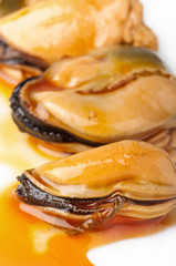Three mussels on a white plate.