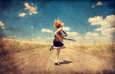 Fototapeta na wymiar Red-head girl with guitar. Photo in old image style.