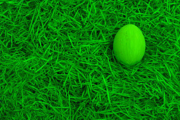 Green painted easter egg in a green easter basket