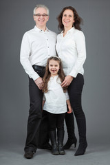 Happy family of father, mother and daughter. Studio shot.