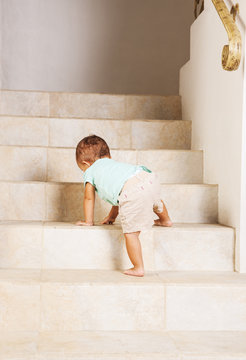 Little girl climbing steps at home