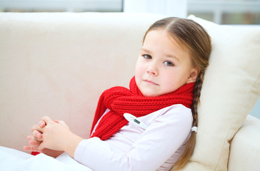 Naklejka premium Ill little girl with thermometer in her mouth