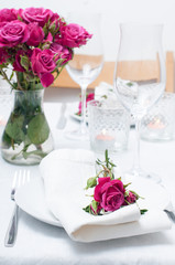 Festive dining table setting with pink roses