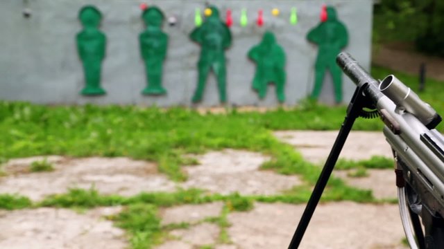 Paintball gun and targets in outdoor shooting gallery