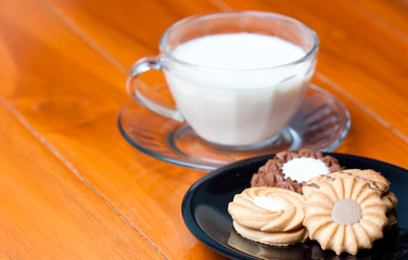 Closeup of cookies on the wood table background with glass of mi