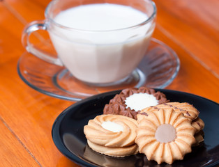 Closeup of cookies on the wood table background with glass of mi