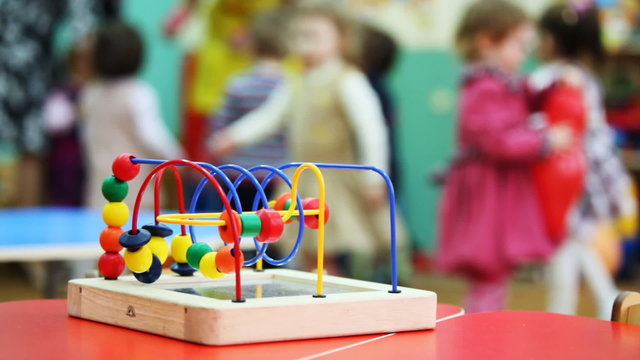 conundrum toy standing on table, in defocus children play