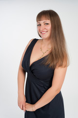 beautiful and young girl posing in a black dress in the studio