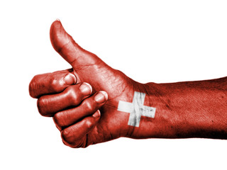 Old woman with arthritis giving the thumbs up sign, wrapped in f