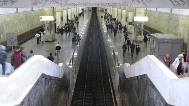 People wait trains on subway station where three railway ways