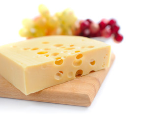 Piece of cheese on a wooden board on a white background