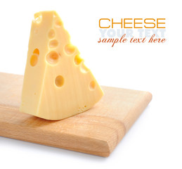 Piece of cheese on a wooden board on a white background