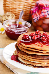 Delicious pancakes with raspberries on the wooden kitchen  table