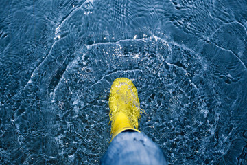 rubber boot splashing in the water - climate concept