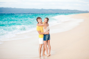 young happy couple having fun on tropical beach. honeymoon