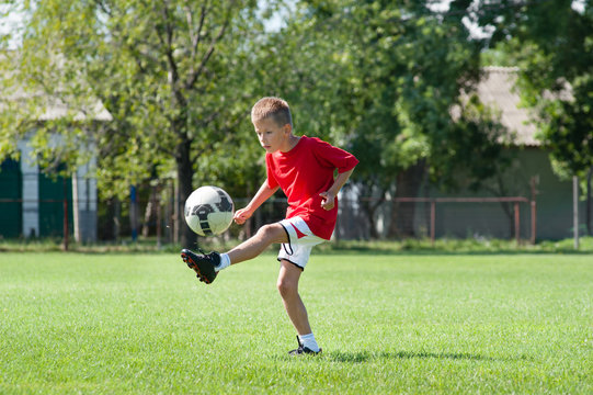 boy kicking football